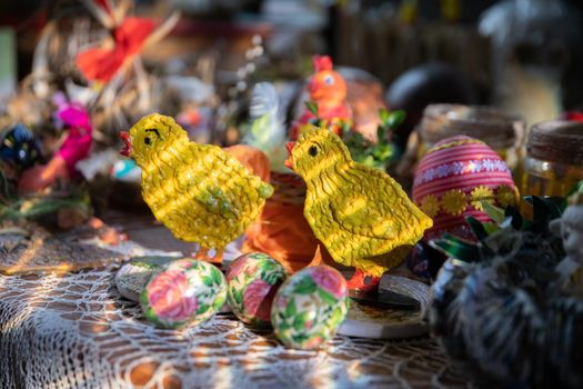 Figures of yellow chicks stand next to Easter eggs. Polish folk masterpiece.