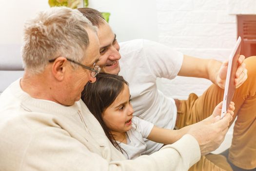 Happy multi generation family, father and adult son, granddaughter.