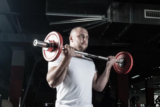 Man in the gym lifts the barbell. bodybuilding and healthy lifestyle