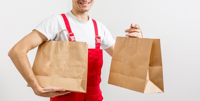 Diverse of paper containers for takeaway food. Delivery man is carrying