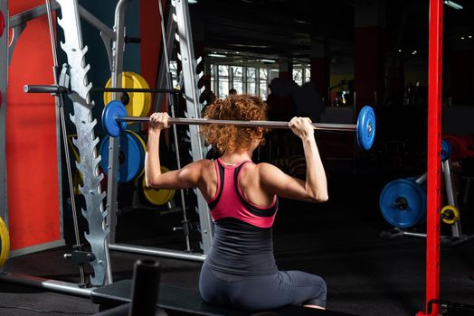 Woman bodybuilder engaged with a barbell in the gym. Healthy lifestyle.