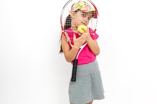 Cute little girl with tennis racket in her hands on white background