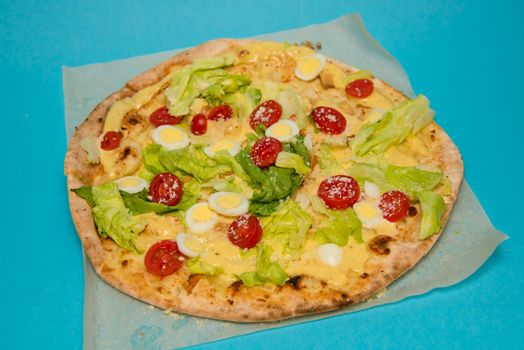 Close up of delicious hot pizza on light blue background. Selective focus.