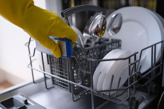 Open dishwasher with clean dishes and housewife. Hygiene and housework concept