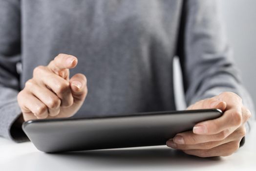 Woman using tablet computer for stock trading. Close-up of female hands touching screen of tablet device. Professional online investing and risk analyzing. Mobile smart device in business process