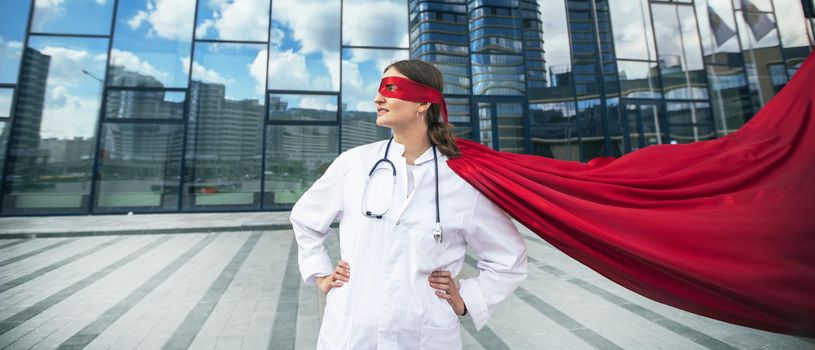 female doctor in a superhero raincoat looks at a city street . photo with a copy-space.