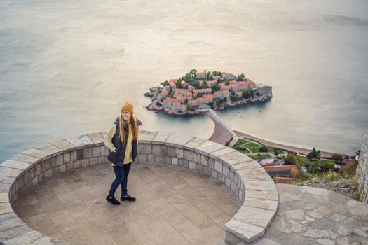 Woman tourist on background of beautiful view of the island of St. Stephen, Sveti Stefan on the Budva Riviera, Budva, Montenegro. Travel to Montenegro concept.