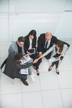 top view. business colleagues shaking hands at an office meeting . photo with a copy of the space