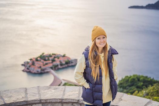 Woman tourist on background of beautiful view of the island of St. Stephen, Sveti Stefan on the Budva Riviera, Budva, Montenegro. Travel to Montenegro concept.