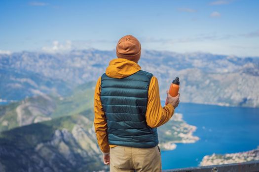 Man tourist enjoys the view of Kotor. Montenegro. Bay of Kotor, Gulf of Kotor, Boka Kotorska and walled old city. Travel to Montenegro concept. Fortifications of Kotor is on UNESCO World Heritage List since 1979.