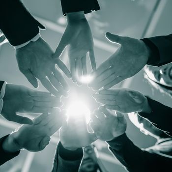 close up. young business team joining their palms in a circle. the concept of teamwork.