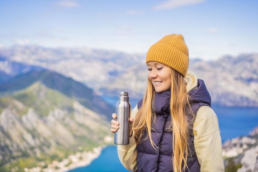 Woman tourist enjoys the view of Kotor. Montenegro. Bay of Kotor, Gulf of Kotor, Boka Kotorska and walled old city. Travel to Montenegro conceptFortifications of Kotor is on UNESCO World Heritage List since 1979.