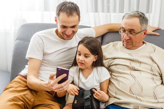 Big happy multigenerational family father, senior grandparents with cute little girl granddaughter at home. Family and love concept.