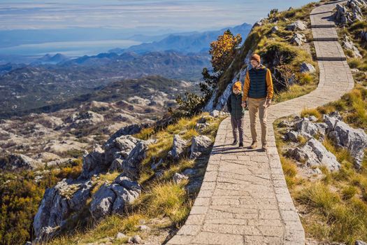 Dad and son travellers in mountain landscape at national park Lovcen, Montenegro. Travel to Montenegro with children concept.