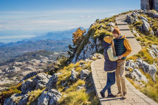 Couple man and woman tourists in mountain landscape at national park Lovcen, Montenegro. Travel to Montenegro concept.