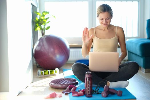 Woman fitness trainer blogger communicates by video call. Remote communication and sports training concept