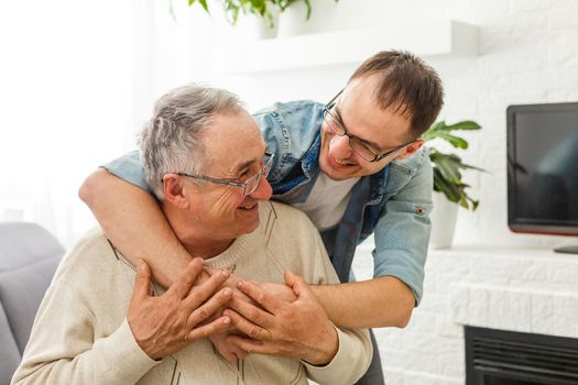 cheerful retired man and adult son talking at home.