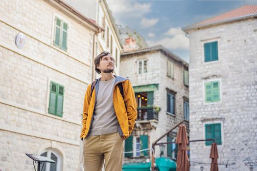 Man tourist enjoying Colorful street in Old town of Kotor on a sunny day, Montenegro. Travel to Montenegro concept.