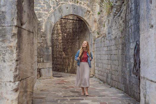 Woman tourist enjoying Colorful street in Old town of Kotor on a sunny day, Montenegro. Travel to Montenegro concept.