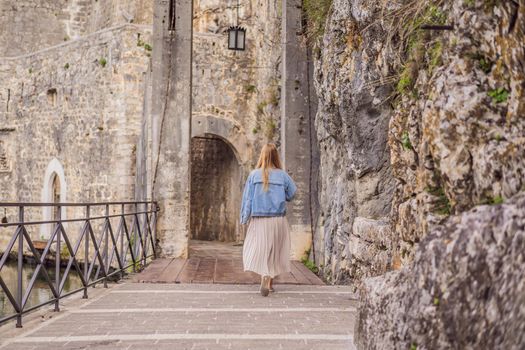 Woman tourist enjoying Colorful street in Old town of Kotor on a sunny day, Montenegro. Travel to Montenegro concept.