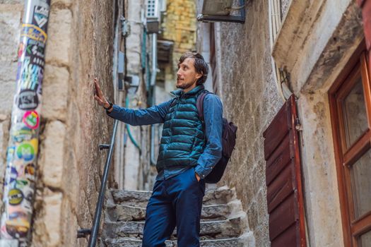 Man tourist enjoying Colorful street in Old town of Kotor on a sunny day, Montenegro. Travel to Montenegro concept.