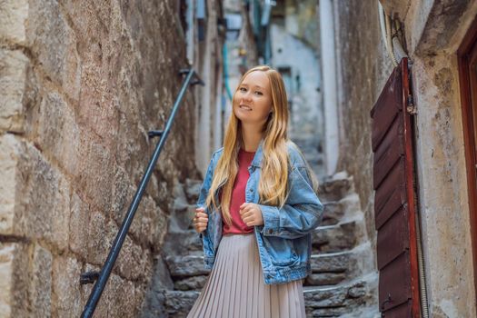 Woman tourist enjoying Colorful street in Old town of Kotor on a sunny day, Montenegro. Travel to Montenegro concept.