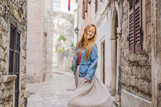 Woman tourist enjoying Colorful street in Old town of Kotor on a sunny day, Montenegro. Travel to Montenegro concept.