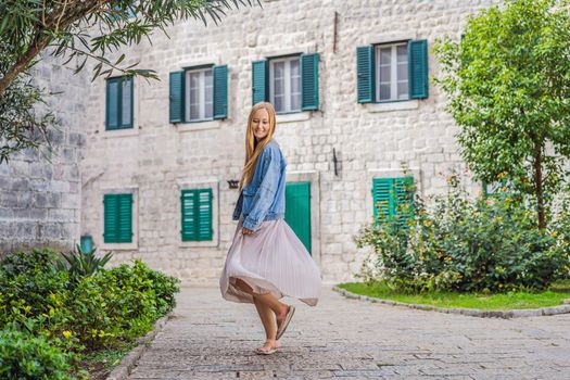 Woman tourist enjoying Colorful street in Old town of Kotor on a sunny day, Montenegro. Travel to Montenegro concept.