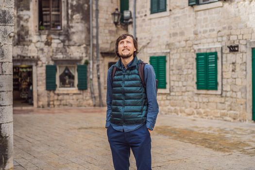 Man tourist enjoying Colorful street in Old town of Kotor on a sunny day, Montenegro. Travel to Montenegro concept.