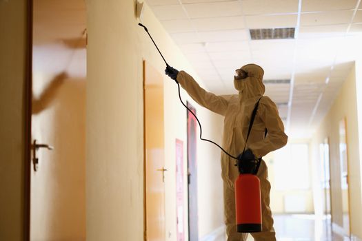 Specialist in protective suit disinfects premises. Cleaning help from viruses and bacteria concept