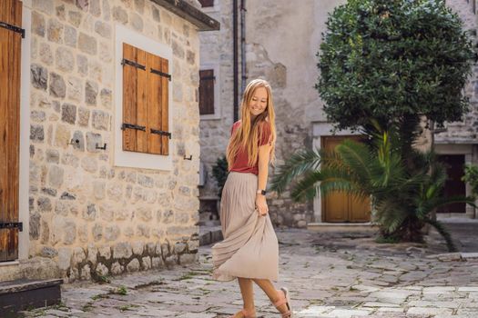 Woman tourist enjoying Colorful street in Old town of Kotor on a sunny day, Montenegro. Travel to Montenegro concept.