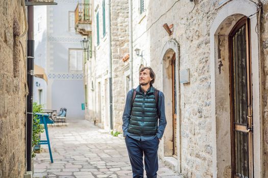 Man tourist enjoying Colorful street in Old town of Kotor on a sunny day, Montenegro. Travel to Montenegro concept.