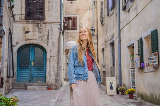 Woman tourist enjoying Colorful street in Old town of Kotor on a sunny day, Montenegro. Travel to Montenegro concept.