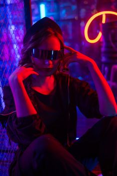 Caucasian woman in sunglasses posing in fog in neon studio