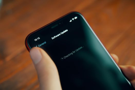 Checking for update actual iOS software operation system on Apple iPhone in hand. Bishkek, Kyrgyz Republic - December 9, 2020