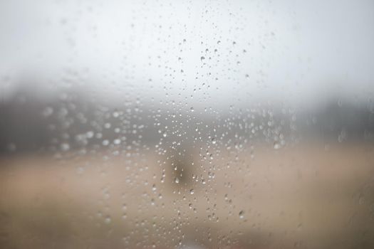 Natural pattern of rain drops on window glass surface