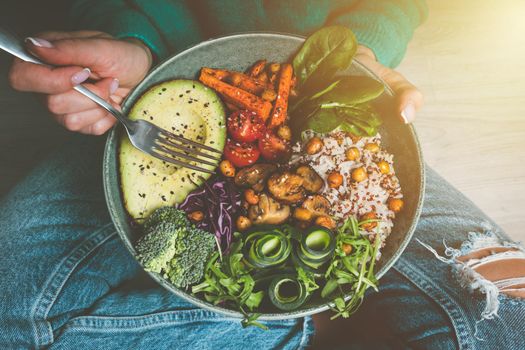 Woman holding plate with vegan or vegetarian food. Healthy diet. Healthy vegetable dinner or lunch. Tasty buddha bowl. Healthy vegan eating. High quality photo