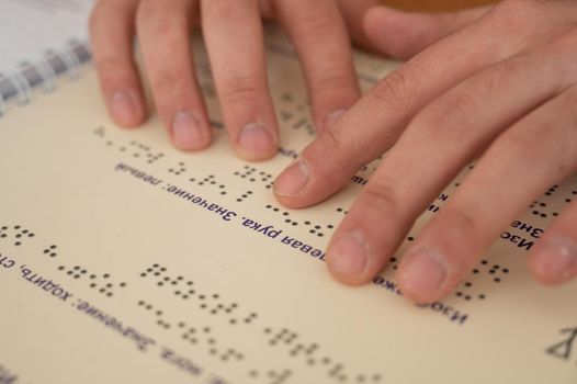Visually impaired man reading a braille book