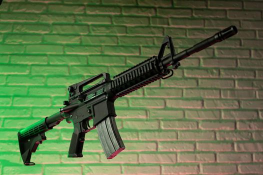 the American army rifle M4A1 against a brick wall