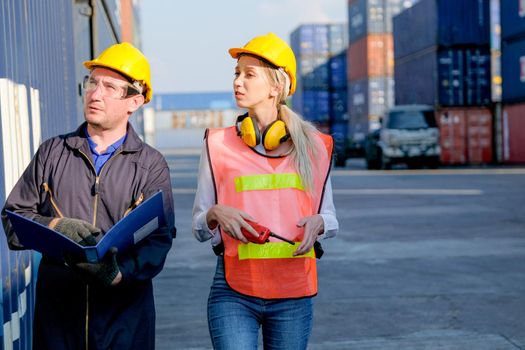 Technician or workers man and woman discuss about the product in cargo container shipping area with day light.