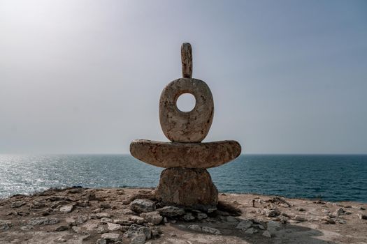 Sculpture symbol made of large pebbles against the blue sky.