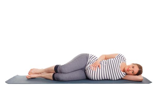 Pregnancy yoga exercise - pregnant woman doing yoga asana Parsva Savasana Side Fetal Pose or Side Lying Corpse Pose isolated on white background
