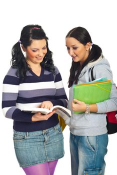 Two students girls reading from a book and having a conversation isolated on white background