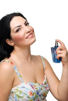 Beautiful woman smiling and holding a blue perfume in her hand isolated on white background