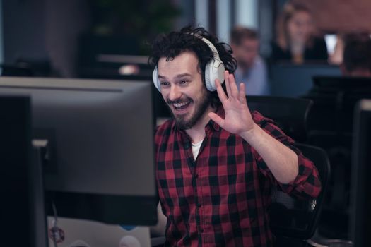 Funny businessman wearing headset having virtual team meeting group call chatting with diverse people in customer support. Video conference call on a computer with manager and employees. High-quality photo