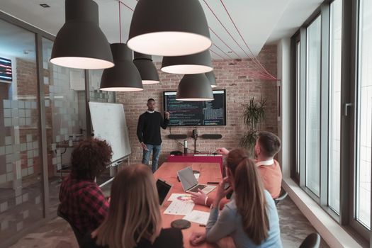 Leader give a business presentation at an office conference meeting, businessman coach mentor explains graph chart on board corporate group workshop training in the boardroom. Selective focus. High-quality photo