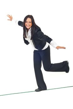 Business woman walking on a tight rope and trying to keep her balance isolated on white background