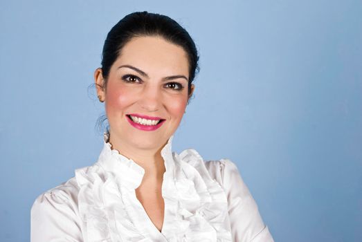 Portrait of smiling beautiful  business woman  in white shirt standing in front of blue background,copy space for text message in right part of image