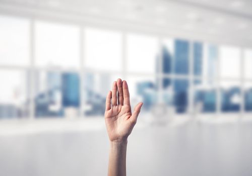 Close of woman hand touching screen with palm and office at background