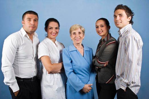 Portrait of happy smiling business people group standing in front of image on blue background